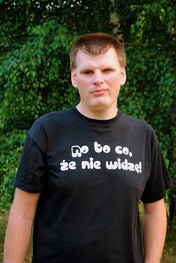 Tomasz Wandzel stoi w koszulce z napisem 