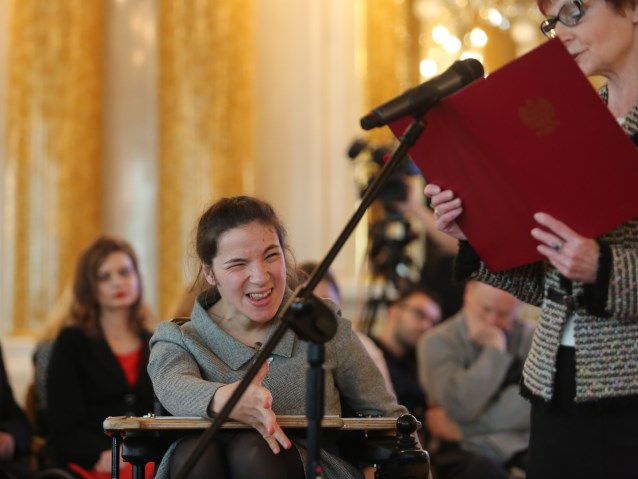 Agnieszka Bal siedzi na wózku, obok przemawiająca w jej imieniu kobieta