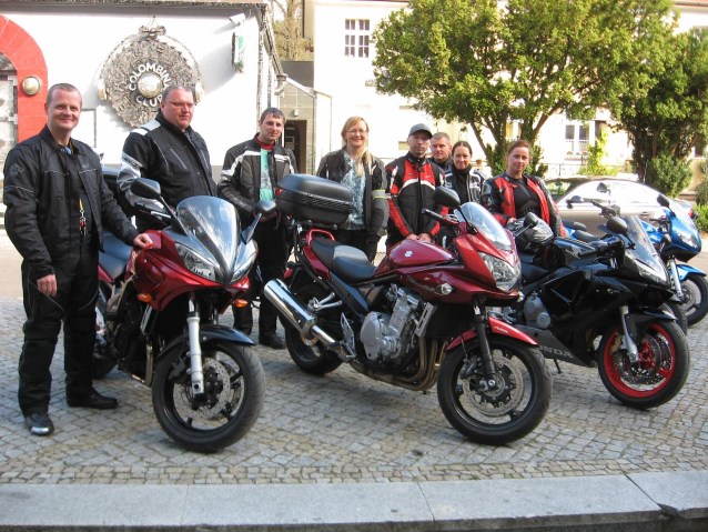 grupa mężczyzn i kobiet z motocyklami pozują do zdjęcia