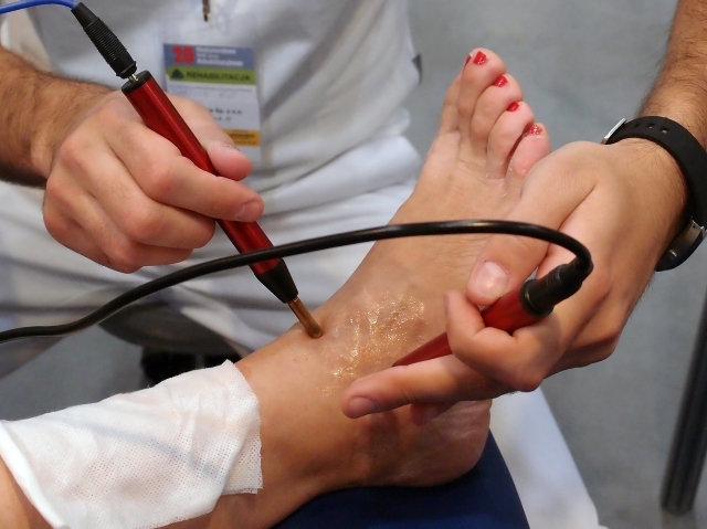 zabieg pacjentki na stopę przy pomocy fizjoterapeuty