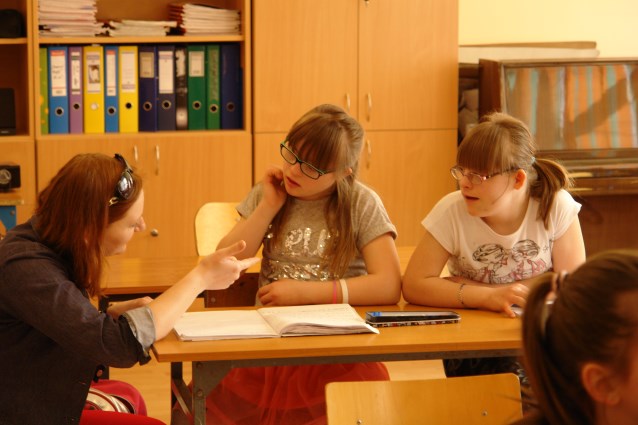asystentka tłumaczy dziewczynkom lekcje