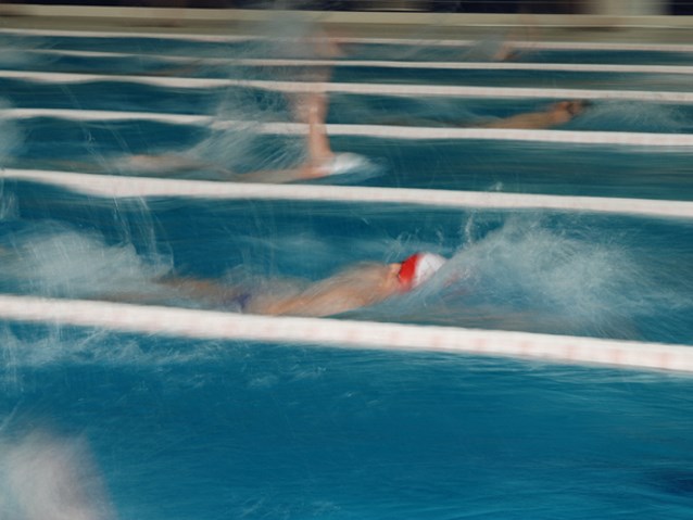 trzech zawodników płynie w basenie