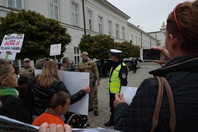 protestujący rodzice przed wejściem na teren Pałacu - stoją przy żołnierzach