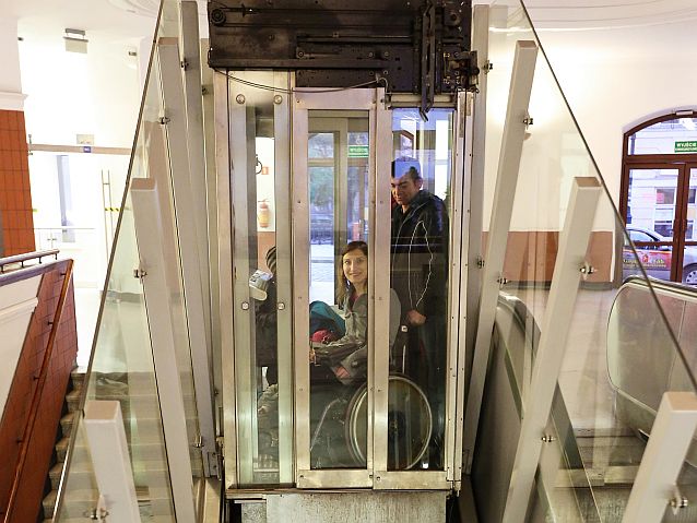 kobieta na wózku z mężem i dzieckiem w windzie