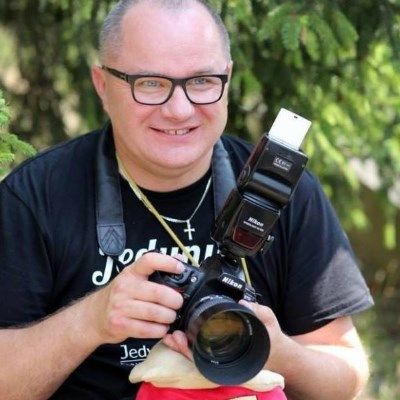 Dariusz Gajko z profesjonalnym aparatem fotograficznym w rękach