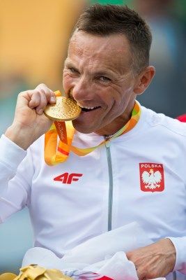 Rafał Wilk w dresie reprezentacji Polski gryzie swój złoty medal zdobyty w Rio
