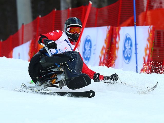 Igor Sikorski, siedzący na sledżu, podczas narciarskiego slalomu