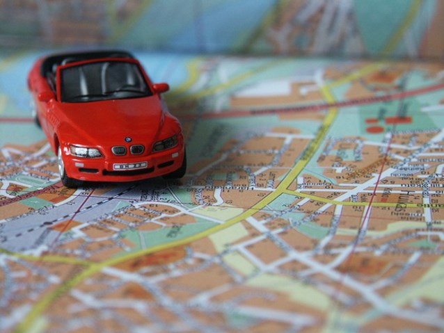 czerwony samochód zabawka stoi na mapie