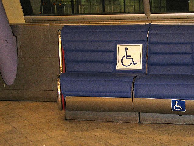Granatowe siedzenia z tabliczką z symbolem osoby na wózku