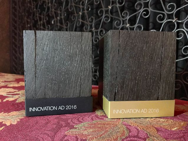 Dwie statuetki w formie sześcianu z czarnego drewna z napisami Innovation AD 2016