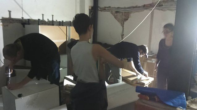 Grupa osób pracująca przy składaniu szafek