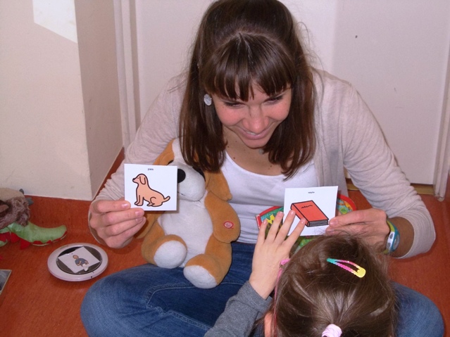 Agata Duda, logopeda podczas pracy - pokazuje dziecku dwa obrazki