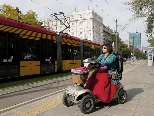 Jolanta Wiszowata na skuterze dla osób z niepełnosprawnością na przystanku tramwajowym