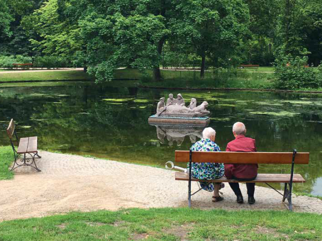 na ławce w parku siedzi para starszych osób 