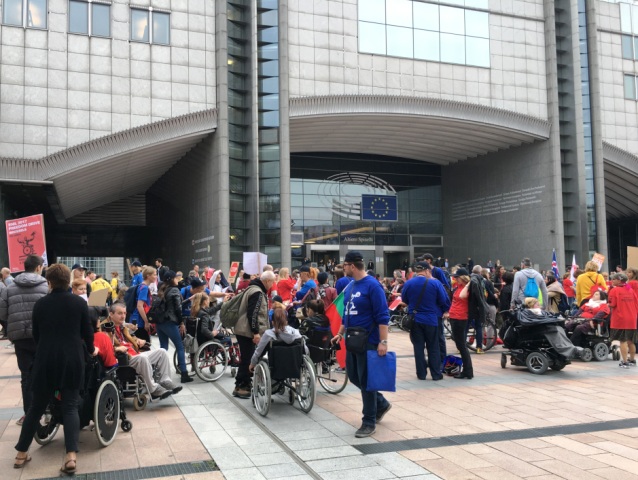 duża grupa osób z niepełnosprawnością z różnych państw prze Parlamentem Europejskim