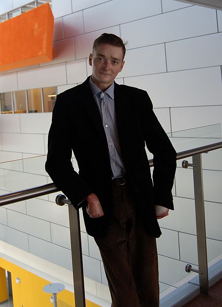 Przemysław Sobieszczuk pozuje do zdjęcia na korytarzu budynku