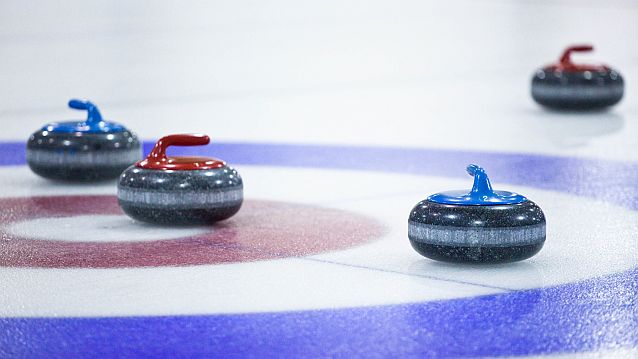 Kamienie do curlingu stoją na lodzie
