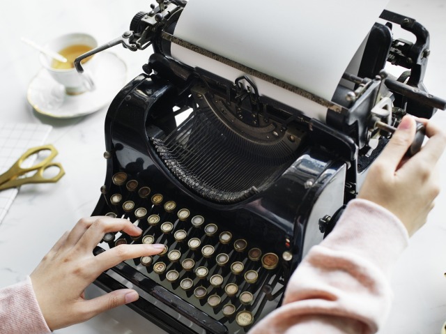 damska dłoń pisze na maszynie do pisania