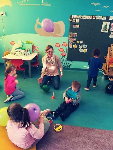 Nauczycielka bawi się na podłodze z czwórką dzieci