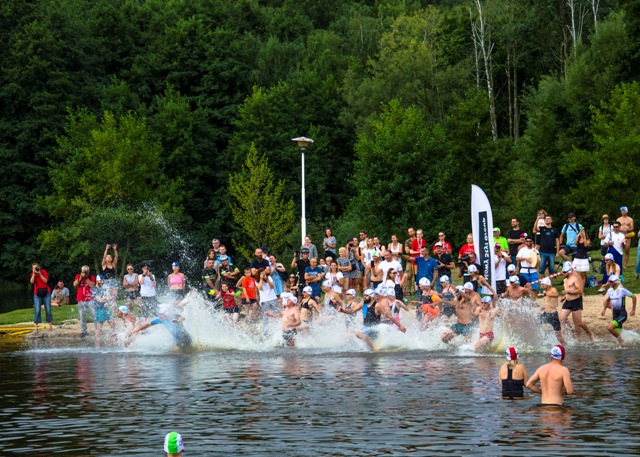 uczestnicy triathlonu rzucają się do wody