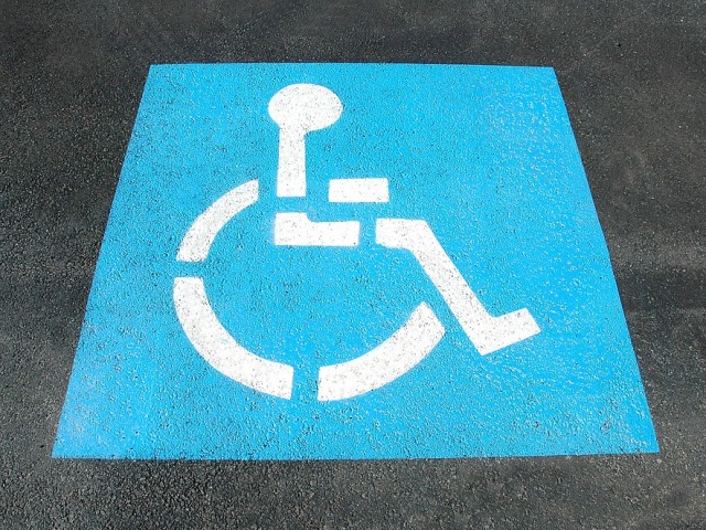 symbol osoby z niepełnosprawnością na parkingu