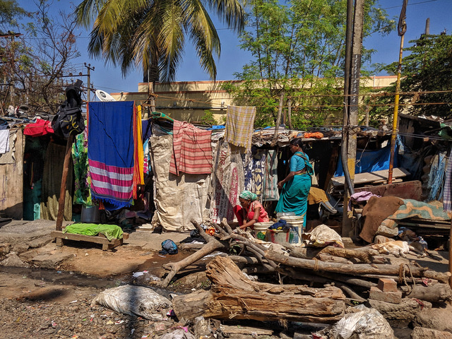 Slumsy w środku miasta, przed domkami skleconymi z przypadkowych materiałów wisi pranie