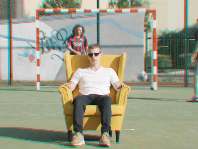 Wojtek Makowski siedzi na żółtym fotelu na boisku za bramką