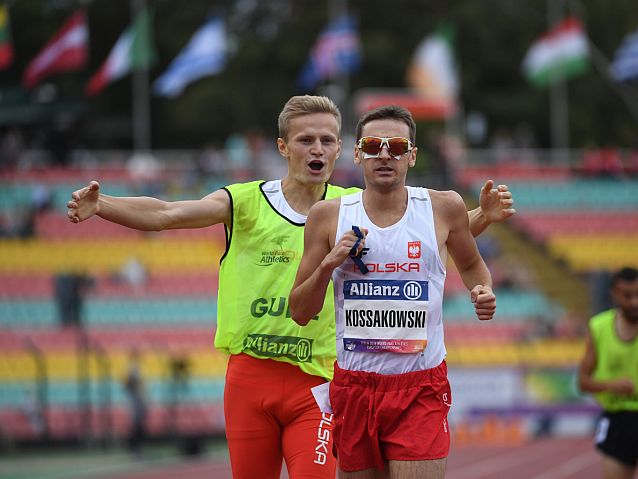 Aleksander Kossakowski biegnie na pierwszym planie, za nim uradowany przewodnik