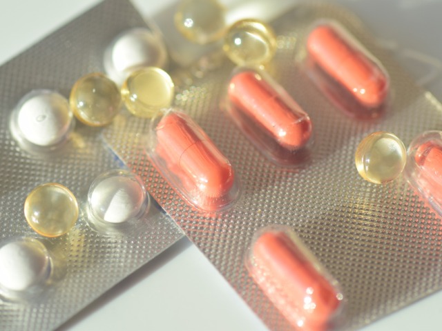 dwie fiolki z kolorowymi tabletkami leżą
