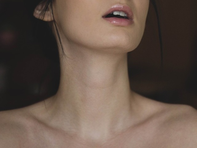 zbliżenie na szyję kobiety i półotwarte usta, pomalowane błyszczykiem