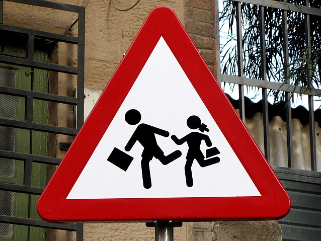 Znak drogowy: uwaga, dzieci! Na znaku biegnący chłopiec i dziewczynka