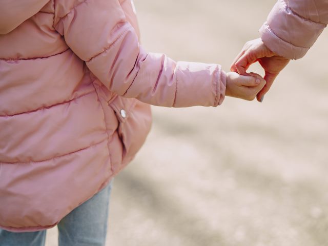 kobieca ręka złączona z ręką dziecka podczas spaceru