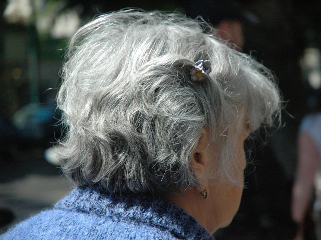 siwe włosy kobiety odwróconej tyłem, są krótkie, lekko pofalowane