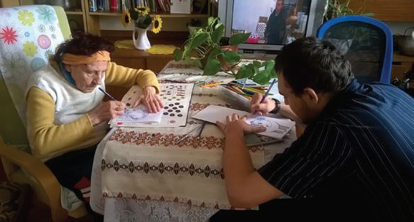 Starsza kobieta i młody mężczyzna rysują ołówkami