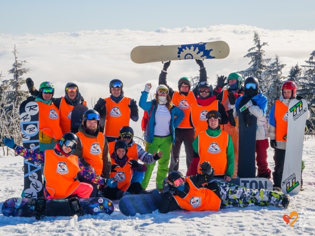 grupa osób z deskami snowboardowymi na śniegu