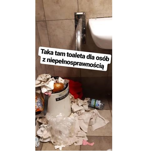 zdjęcie z łazienki przepełniony kosz na śmieci gdzie leży papier, butelka plasikowa, z kosza wystaje chleb na górze napis taka tam toaleta dla osób z niepełnosprawnością
