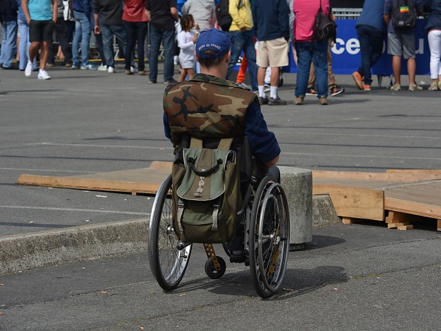 mężczyzna na wózku odwrócony tyłem na ulicy