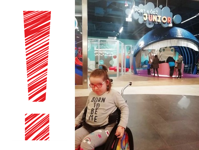 dziewczynka na wózku na tle placu zabaw w Porcie Łódź, po lewej stronie zdjęcia dodano czerwony wykrzynik