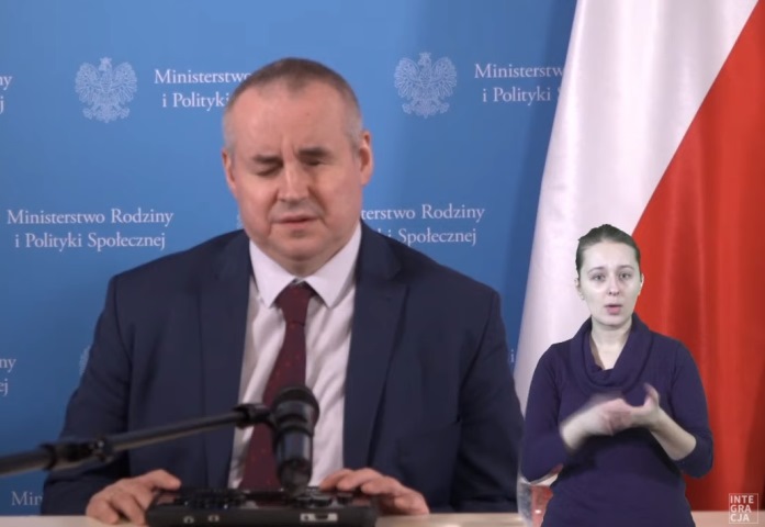 minister Paweł Wdówik podczas czatu na żywo po prawej sylwetka tłumacza PJM w prawym rogu logo integracji