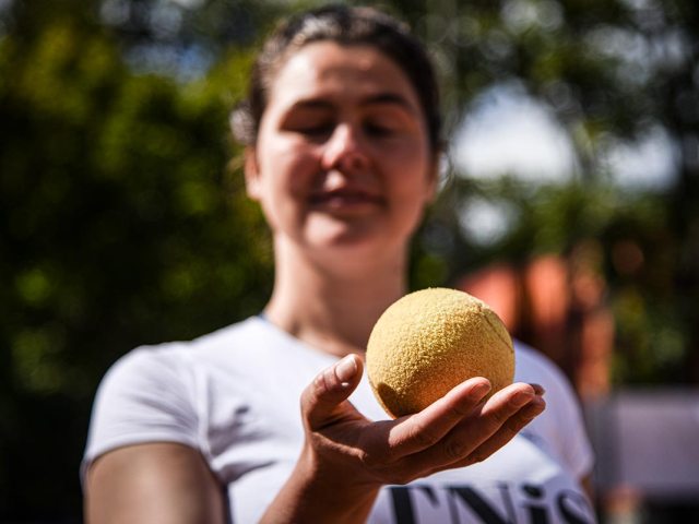 niewidoma kobieta trzyma w dłoni piłkę od tenisa