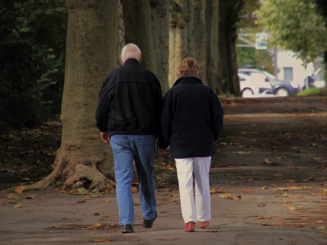 dwoje emerytów idzie scieżką w parku