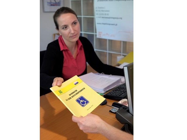 doradca zawodowy Magda Sarnecka wręcza broszurę informator dla osób niepełnosprawnych