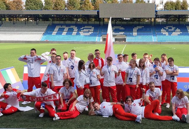 Murawa na stadionie. Polska reprezentacja na Igrzyskach Eurotrigames, składająca się z kilkudziesięciu osób. 