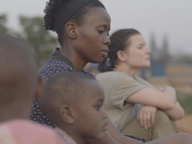 kadr z filmu siedzą obok siebie jowita budnik i Eliane Umuhire oraz dziecko afroamerykańskie