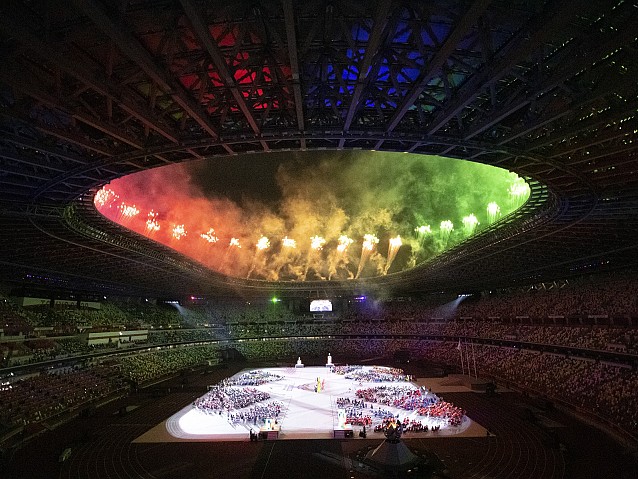 Fajerwerki nad stadionem olimpijskim. Na płycie stadionu stoją zawodnicy