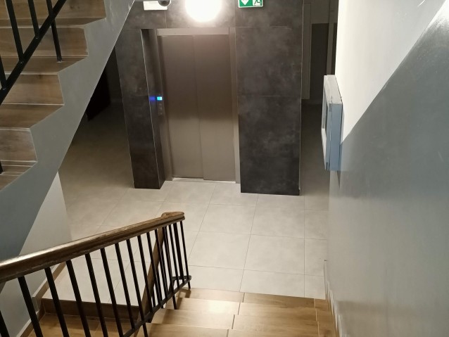 Widok w dół schodów na klatce schodowej na zamkniętą windę