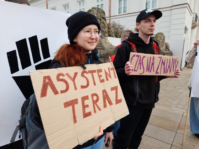 Dwoje uczestników protestów. Dziewczyna trzyma transparent z napisem 