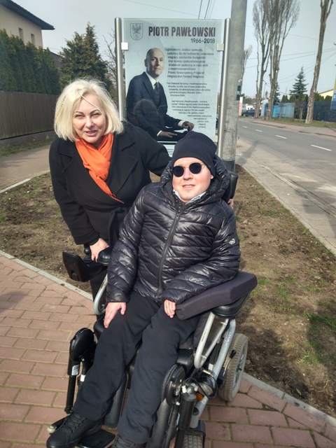 Ewa Pawłowska z Wojciechem Kowalczykiem na tle tablicy Piotra Pawłowskiego