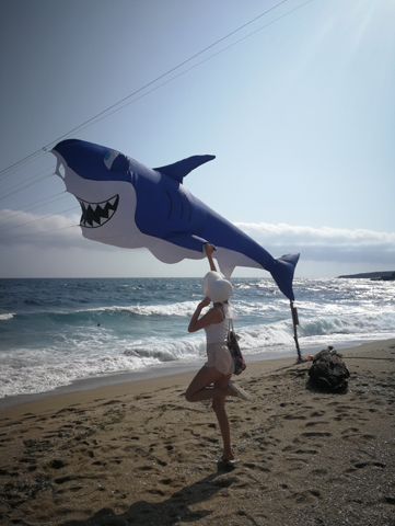 dziewczyna w białym kapeluszu dotyka latawca rekina