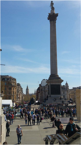 wielki plac Trafalgar Square, na środku stoi kolumna, w oddali Big Ben